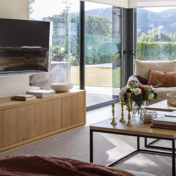 Salón moderno sofá gris estores mueble tv madera